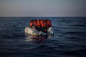 In this photo taken on Saturday Sept. 10, 2016, African refugees and migrants wait aboard a partially punctured rubber boat to be assisted, during a rescue operation on the Mediterranean Sea, about 13 miles North of Sabratha, Libya. (AP Photo/Santi Palacios)