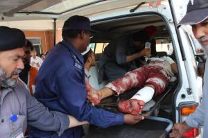 Pakistani volunteers carry an injured person who arrived from Mardan, at a local hospital in Peshawar, Pakistan, Friday, Sept. 2, 2016. Northwestern Pakistan was struck by two separate militant attacks on Friday, when gunmen wearing suicide vests stormed a Christian colony near the town of Peshawar, killing one civilian, and a suicide bomb attack on a district court in the town of Mardan killed scores of people and wounded many. (AP Photo/Mohammad Sajjad)