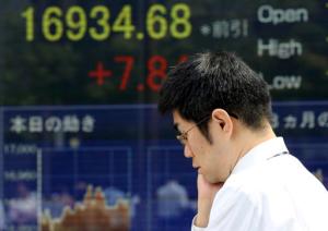 A man walks by an electronic stock board of a securities firm in Tokyo, Friday, Sept. 2, 2016. Most Asian markets were listless Friday as investors awaited key U.S. job data that could influence the Fed's interest rate policy. (AP Photo/Koji Sasahara)