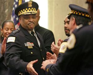 FILE - In this April 13, 2016 file photo, Chicago's police superintendent Eddie Johnson, left, shakes hands with other officers at a city council meeting in Chicago. The Chicago Police Department plans to hire more than 500 additional officers as it struggles to deal with a violent year full of killings and gun crimes, a city official told The Associated Press on Tuesday Sept. 20, 2016. Chicago Police Superintendent Eddie Johnson will announce the hires Wednesday, according to the official. (AP Photo/M. Spencer Green File)