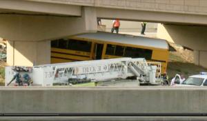 In this image made from video provided by KMGH/THEDENVERCHANNEL.COM, emergency personnel stand near the scene of a school bus that crashed into a concrete pillar in Denver,  Sunday, Sept. 11, 2016. The school bus driver was killed Sunday and several others were seriously injured after the bus veered off a roadway at Denver International Airport and crashed into a concrete pillar, police said. (KMGH/THEDENVERCHANNEL.COM via AP)