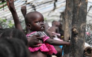FILE - In this Monday, July 25, 2016 file photo, a baby is lifted up as people queue for food distribution in a camp for the displaced at the United Nations base in Juba, South Sudan. The United Nations said Friday, Sept. 9, 2016 that hunger in South Sudan has reached "unprecedented" levels, with nearly 5 million people suffering from severe food insecurity. (AP Photo/Justin Lynch, File)