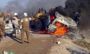 This photo provided by the Syria Press Center (SPC), an anti-government media group, shows rescue workers using a bulldozer to remove a burned van after airstrikes hit west of the town of Suran in Hama province, Syria, Thursday Sept. 1, 2016, killing a dozen people. Suspected government warplanes carried out a series of airstrikes in Hama amid a lightning advance by insurgents on government-controlled areas in the province. (Syria Press Center via AP)