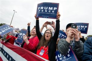 Joan Hughes, center, of Rockingham County, Va., holds a sign of support as Republican vice-presidential nominee Indiana Gov. Mike Pence enters to speak at a rally on the Rockingham County Fairgrounds Wednesday, Oct. 5, 2016, in Harrisonburg, Va. (Nikki Fox/Daily News-Record via AP)
