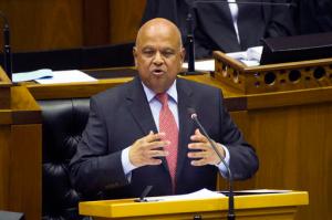 FILE - In this Oct. 26, 2016 file photo, South African finance minister Pravin Gordhan delivers the midterm budget speech inside parliament in Cape Town, South Africa. Prosecutors have dropped fraud charges against Gordhan and two former tax officials,  Monday Oct. 31, 2016, reversing a decision that was criticized by South Africans and deepened concern about the country's economy and political leadership. (AP Photo/Rodger Bosch, Pool, File)