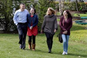 From left, Peter Foster; adopted daughter; Kerry, 12; his wife, Susan, and their biological daughter, Emma, 17, walk on the grounds outside St. Barnabas Hospital, in Livingston, N.J., Tuesday, Oct. 25, 2016. More than 15 years ago, 17 babies, including Emma, were born after an experimental infertility treatment that gave them DNA from three people: Mom, Dad and an egg donor. Now researchers have checked up on how the babies are doing as teenagers. The preliminary verdict: The kids are all right. (AP Photo/Richard Drew)