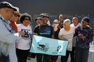 In this photo taken Saturday, Oct. 8, 2016, former members of the Black Panther Party laugh and visit outside a museum after an anniversary meeting in Oakland, Calif. In the front row is Billy X. Jennings, center, M. Gayle Asali-Dickson, second from right and Lorene Johnson, right. Hundreds of former Black Panthers from around the world are expected to gather in Oakland, Calif., for a four-day conference that started Thursday, Oct. 20, 2016. The Panthers emerged from the gritty city 50 years ago, declaring a new party dedicated to defending African-Americans against police brutality and protecting their rights. (AP Photo/Eric Risberg)