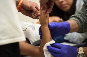 In this Oct. 24, 2016 photo, Orthopedic technician Francisco Blasco Reillo attends to a patient at the Medical Center pediatric orthopedics clinic in San Juan, Puerto Rico. The exodus of doctors to the United States in search of better wages is one of the main factors linked to the current shortage of specialists in the Island. (AP Photo/Carlos Giusti)