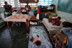 People whose homes were destroyed by Hurricane Matthew begin their day inside a school where they have sought shelter in Port Salut, Haiti, Tuesday, Oct. 11, 2016. While some families like these were able to recover mattresses, furniture, and household goods from under the mud, others lost everything. The scores of people sheltering at this school have been told they have one more week before they have to move out so classes can restart. (AP Photo/Rebecca Blackwell)