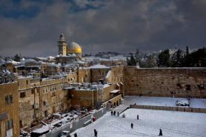 File - In this Dec. 13, 2013 file photo, the Western Wall, right, and the gilded Dome of the Rock, among the holiest sites for Jews and Muslims, are covered in snow. Israel has suspended cooperation with UNESCO on Friday, Oct. 14, 2016, a day after the U.N. cultural agency adopted a draft resolution that Israel says denies the deep, historic Jewish connection to holy sites in Jerusalem. UNESCO's draft resolution, sponsored by several Arab countries, uses only the Islamic name for a hilltop compound sacred to both Jews and Muslims, which includes the Western Wall, a remnant of the biblical temple and the holiest site where Jews can pray. (AP Photo/Dusan Vranic, File)