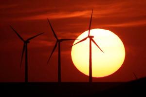 FILE - In this Aug. 23, 2013 file photo, wind turbines are silhouetted by the setting sun as they produce electricity near Beaumont, Kan. Energy independence has been a goal of every president since Richard Nixon. Hillary Clinton and Donald Trump have very different ways to achieve it. How energy is produced and where it comes from affect jobs, the economy and the environment. (AP Photo/Charlie Riedel, File)