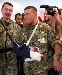 FILE - In this Friday, July 11, 2014 file photo, a platoon commander Arsen Pavlov, also known as Motorola, center, attends his and Elena Kolenkina's wedding ceremony with Igor Strelkov, left, a pro-Russian separatist commander, in Donetsk, eastern Ukraine. The separatist mouthpiece Donetsk News Agency said on Sunday, Oct. 16, 2016, Pavlov was killed in Donetsk when a bomb went off in an elevator in the house he was staying. (AP Photo/Dmitry Lovetsky, File)