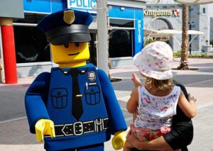 An actor dressed as a Lego police officer mini-figure greets a child at Legoland Dubai, in Dubai, United Arab Emirates, Monday, Oct. 31, 2016. The Legoland park, part of the larger Dubai Parks & Resorts project, is the first among its planned attractions to opens. (AP Photo/Jon Gambrell)