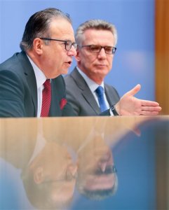 Federal Minister of the Interior Thomas de Maiziere and head of the Federal Agency of Migration and Refugees Frank-Juergen Weise hold a press conference regarding the numbers of asylum seeker for September 2016 as well as the third quarter 2016 in the Federal press conference in Berlin, Germany, Oct. 12, 2016. (Kay Nietfeld/dpa via AP)