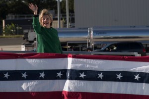 Democratic presidential candidate Hillary Clinton waves at reporters as she boards her campaign plane at an international airport, Sunday, Oct. 23, 2016, in Morrisville, N.C. (AP Photo/Mary Altaffer)