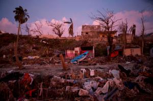 A boat lies washed up amidst Haitian army buildings damaged by Hurricane Matthew, in a seaside fishing neighborhood in Port Salut, Haiti, Sunday, Oct. 9, 2016. Five days after the storm smashed into southwestern Haiti, some communities along the southern coast have yet to receive any assistance, leaving residents who have lost their homes and virtually all of their belongings struggling to find shelter and potable water.(AP Photo/Rebecca Blackwell)