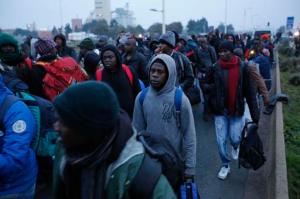 Migrants line-up to register at a processing centre in the makeshift migrant camp known as "the jungle" near Calais, northern France, Monday Oct. 24, 2016. French authorities say the closure of the slum-like camp in Calais will start on Monday and will last approximatively a week in what they describe as a "humanitarian" operation. (AP Photo/Emilio Morenatti)