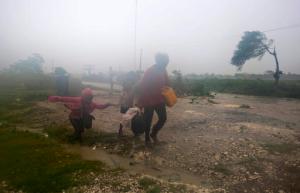 Residents head to a shelter in Leogane, Haiti, Tuesday, Oct. 4, 2016. Matthew slammed into Haiti's southwestern tip with howling, 145 mph winds Tuesday, tearing off roofs in the poor and largely rural area, uprooting trees and leaving rivers bloated and choked with debris.  (AP Photo/Dieu Nalio Chery)