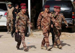 The Commander of the Joint Military Operation Commander, Army Lt. Gen. Talib Shaghati, center, walks in the town of Khazer, Iraq, Wednesday, Oct. 19, 2016. The senior Iraqi general on Wednesday called on Iraqis fighting for the Islamic State group in Mosul to surrender as a wide-scale operation to retake the militant-held city entered its third day. (AP Photo/Khalid Mohammed)