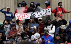 FILE - In this Oct. 4, 2016, file photo, a protester, centre left, addresses fellow students outside the Great Hall at the University of the Witwatersrand in Johannesburg, South Africa. In a racially charged scene, a mostly black group of student protesters on Wednesday confronted white students who want protests for free education to stop so they can complete the academic year. (AP Photo/Themba Hadebe, File)