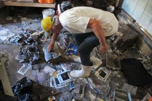 In this Oct. 12, 2016 photo, Walter Coker surveys the damage in his furniture storage shed in Crescent Beach, Fla. Coker runs Genung's Fish Camp and Marina on the shore of the Matanzas River, and saw storm surge from Hurricane Matthew run "like a river" through his property, tearing apart the storage shed and the tackle shop. He doesn't have flood insurance because he said it was too expensive, so is hoping to rebound with the help of neighbors and the community. (AP Photo/Jason H. Dearen)