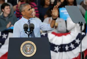 President Barack Obama waves at a protester being escorted out after interrupting his speech during a campaign rally for Democratic presidential candidate Hillary Clinton in Greensboro, N.C., Tuesday, Oct. 11, 2016. (AP Photo/Chuck Burton)