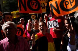 Supporters of Spain's Socialist party leader Pedro Sanchez hold placards that read: "No Popular Party" as they shout slogans outside the party headquarters in Madrid, Saturday, Oct. 1, 2016. Spain's Socialist party is facing strong internal discord as they vote to decide if they will keep or oust their leader Pedro Sanchez, who has been leading opposition to acting conservative Prime Minister Mariano Rajoy's efforts to build a minority government and end a nine-month political deadlock. (AP Photo/Francisco Seco)
