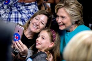 Democratic presidential candidate Hillary Clinton takes a photograph with supporters at a campaign office in Seattle, Friday, Oct. 14, 2016. (AP Photo/Andrew Harnik)