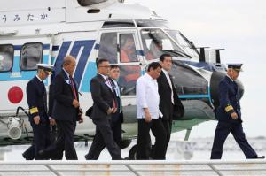 FILE - In this Thursday, Oct. 27, 2016 file photo, Philippine President Rodrigo Duterte, center in white outfit, is escorted on a ship upon his arrival by a helicopter at a Japan Coast Guard base in Yokohama near Tokyo. Duterte proposed joint military exercises with Japan during his visit to Tokyo, while reiterating that he will not conduct them with Americans in his presidency. Duterte made the proposal during his visit to a coast guard unit to observe an exercise from one of the patrol vessels Japan pledged to provide the Philippines to upgrade Manila's maritime security capabilities, largely in response to China’s strong assertions of its South China Sea maritime claims. (AP Photo/Eugene Hoshiko, File)