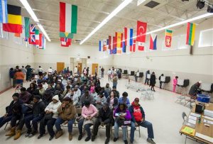 Voters sit in rows of chairs at Rosemont Middle School as they wait their turn to cast their ballots on Election Day in Norfolk, Va., Tuesday, Nov. 8, 2016.  (Bill Tiernan/The Virginian-Pilot via AP)