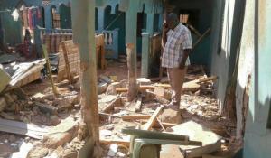 A man stands amid the debris at the scene of an attack in the town of Mandera, Kenya, near the border with Somalia, Tuesday, Oct. 25, 2016. A Kenyan official says a number of people were killed in the extremist attack and that gunmen from the Somalia-based extremist group al-Shabab are suspected of carrying out the attack. (AP Photo)