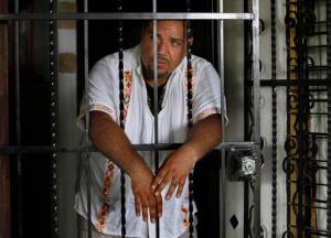 In this July 2, 2016 photo, Juan Carlos Soni Bulos stands behind the wrought iron door of his house in Tanquian de Escobedo, San Luis Potosi, Mexico. Soni was enrolled in a government protection program as of June 26, 2013, but was detained by marines, blindfolded, bound and taken with four relatives and friends and tortured. (AP Photo/Marco Ugarte)