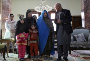 Afghan President Ashraf Ghani, right, poses for photographers during a meeting with National Geographic's famed green-eyed "Afghan Girl," Sharbat Gulla, and family, at the Presidential palace in Kabul, Afghanistan, Nov. 9, 2016. Afghanistan's president on Wednesday welcomed home Gulla who was deported from Pakistan after a court had convicted her on charges of carrying a forged Pakistani ID card and staying in the country illegally. (AP Photo/Rahmat Gul)