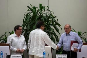 Humberto de La Calle, right, head of Colombia's government peace negotiation team, right, shakes hands with Ivan Marquez, chief negotiator of the Revolutionary Armed Forces of Colombia, or FARC, as Cuba's Foreign Minister Bruno Rodriguez, watches, after the signing of the latest peace accord between the two sides in Havana, Cuba, Saturday, Nov. 12, 2016. Colombia's government and its largest rebel group signed a new, modified peace accord on Saturday following the surprise rejection of an earlier deal by voters in a referendum. (AP Photo/Desmond Boylan)