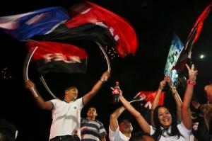 Supporters of Nicaragua's President Daniel Ortega and vice presidential candidate, his wife, Rosario Murillo wave flags of the Sandinista National Liberation Front, or FSLN, as Ortega won re-election, while celebrating in Managua, Nicaragua, Sunday, Nov. 6, 2016. Ortega won re-election to a third consecutive term as Nicaragua's leader, electoral officials said late Sunday as they released early results from an election that the opposition called a farce. (AP Photo/Esteban Felix)