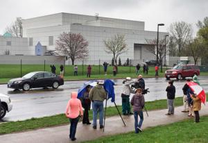 FILE - In this April 21, 2016 file photo, people stand outside the entertainer Prince's Paisley Park compound in Chanhassen, Minn. Following a Chanhassen City Council rezoning vote on Monday, Oct. 24, 2016, Prince's Paisley Park recording studio and home will begin operating as a permanent museum. The museum's website said tours will begin again Friday, Oct. 28. (Jim Gehrz/Star Tribune via AP, File)
