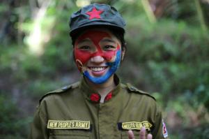 In this photo taken Nov. 23, 2016, a 24-year-old New People's Army guerrilla, who uses the nom de guerre Comrade Katryn, smiles as she talks to reporters at a rebel encampment tucked in the harsh wilderness of the Sierra Madre mountains southeast of Manila, Philippines. Communist guerrillas warn that a peace deal with President Rodrigo Duterte's government is unlikely if he won't end the Philippines' treaty alliance with the United States and resist control by other countries. (AP Photo/Aaron Favila)