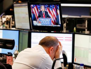 A broker reacts as President-elect Donald Trump shows up on a television screen at the stock market in Frankfurt, Germany, Wednesday, Nov. 9, 2016. (AP Photo/Michael Probst)