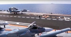 In this photo made from the footage taken from Russian Defense Ministry official web site on Tuesday, Nov. 15, 2016, Russian Su-33 fighter jets stand on the flight deck of the Admiral Kuznetsov aircraft carrier in the eastern Mediterranean Sea. The Russian military on Tuesday launched a series of strikes on militant targets in Syria involving carrier-borne fighters, marking the Admiral Kuznetsov's combat debut. (Russian Defense Ministry Press Service/ Photo via AP)