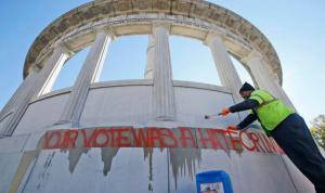 City workers prepare to clean graffiti from the statue of Confederate President Jefferson Davis in Richmond, Va., Thursday, Nov. 10, 2016. The graffiti reads "Your Vote Was A Hate Crime." (AP Photo/Steve Helber)