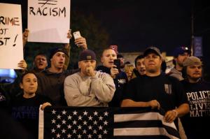 Chicago Police Department supporters watch as Black Lives Matter activists and supporters of the Beal family rally  Tuesday, Nov. 8, 2016, in the wake of the fatal shooting of Joshua Beal in the Mount Greenwood neighborhood of Chicago. The predominantly white neighborhood on Chicago's southwest side has been rocked by confrontations between protesters and police supporters for the second time since the fatal shooting of a black man by police over the weekend. (E. Jason Wambsgans//Chicago Tribune via AP)