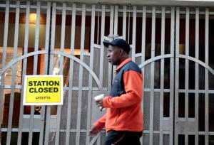 A pedestrian passes a locked rail station in west Philadelphia Tuesday Nov. 1, 2016. Commuters scrambled Tuesday to find alternate ways to travel as transit workers in Philadelphia hit the picket lines after the city's main transit agency and a union representing about 4,700 workers failed to reach a contract agreement. The union went on strike at 12:01 a.m. Tuesday, shutting down Southeastern Pennsylvania Transportation Authority buses, trolleys and subways that provide about 900,000 rides a day. (AP Photo/Jacqueline Larma)