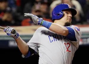 In this Tuesday, Oct. 25, 2016, photo, Chicago Cubs' Kyle Schwarber, wearing a green wristband on his left arm, hits a double during the fourth inning of Game 1 of the Major League Baseball World Series against the Cleveland Indians in Cleveland. Some 1,700 miles away from Wrigley Field, no one is enjoying Schwarber's comeback from a major knee injury more than Campbell Faulkner, a boy with a life-threatening illness, and his family. The 10-year-old Faulkner stays up to watch his buddy in the World Series, and Schwarber proudly wears his Campbell’s Crew wristband while he tries to help the Chicago Cubs to their first championship since 1908. (AP Photo/David J. Phillip)