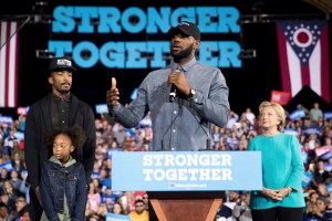 LeBron James, center, accompanied by Cleveland Cavaliers basketball player J. R. Smith, left, his daughter Demi, bottom left, and Democratic presidential candidate Hillary Clinton, right, speaks at a rally at the Cleveland Public Auditorium in Cleveland, Sunday, Nov. 6, 2016. (AP Photo/Andrew Harnik)