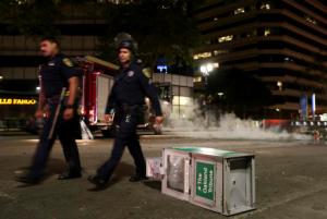 Police officers walk past an overturned newspaper rack during protests in Oakland, Calif., late Tuesday, Nov. 8, 2016. President-elect Donald Trump’s victory set off multiple protests. (Anda Chu/Bay Area News Group via AP)