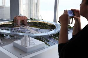 A woman takes a photograph of a model of the Hyperloop One project during a news conference in Dubai, United Arab Emirates, Tuesday, Nov. 8, 2016. The futuristic city-state of Dubai announced a deal on Tuesday with Los Angeles-based Hyperloop One to study the potential for building a line linking it to the Emirati capital of Abu Dhabi. (AP Photo/Jon Gambrell)