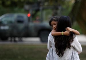 A woman carries her child near a military truck, after soldiers evacuated Plaza Las Americas mall following gunfire in Cancun, Mexico, Tuesday, Jan. 17, 2017. Gunmen attacked the state prosecutor's office in this Caribbean resort city Tuesday, ratcheting up tensions just a day after a deadly shooting at a music festival in a nearby town. (AP Photo/Rebecca Blackwell)