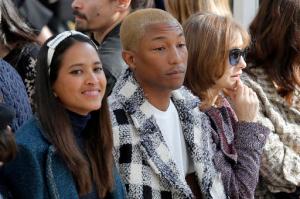 FILE - In this March 8, 2016, file photo, from left, Helen Lasichanh, her husband, Pharrell Williams, and French actress Isabelle Huppert attend the Chanel's Fall-winter 2016-2017 ready to wear collection presented in Paris. Williams' publicist said on Jan. 31, 2017, that he and Lasichanh have welcomed triplets. (AP Photo/Francois Mori, File)