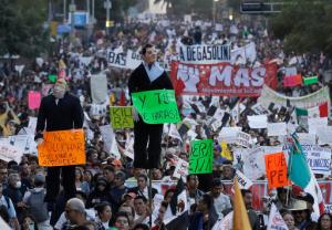 People carry effigies of Mexican President Enrique Pena Nieto and U.S. President-elect Donald Trump, as thousands marched in anger against the government following a 20 percent rise in gas prices, in Mexico City, Monday, Jan. 9, 2017. The effigy of Pena Nieto, holding a sign reading in Spanish "And what would you do?" and that of Trump, marked with "I don't know how to struggle, but I came here to learn," were later burned. (AP Photo/Rebecca Blackwell)