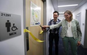 Abe Noe-Hays, director of research at the Vermont-based Rich Earth Institute, left, and Nancy Love, professor of civil and environmental engineering at the University of Michigan cut the ribbon to a men's bathroom with a special toilet at the University of Michigan engineering building, Tuesday, Jan. 24, 2017, in Ann Arbor, Mich. The toilet is part of a multi-state project researching the conversion of human urine into fertilizer. (AP Photo/Carlos Osorio)